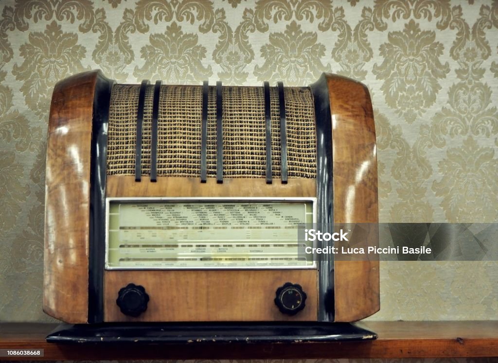 Very Old Vintage Radio On A Wooden Shelf Retro Style Wallpaper In The  Background Stock Photo - Download Image Now - iStock