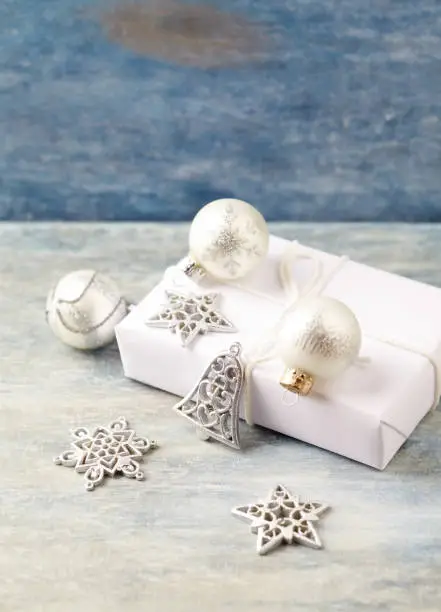 Christmas decoration and present. Christmas stars, bell and silver baubles.  Christmas time. Wooden background.