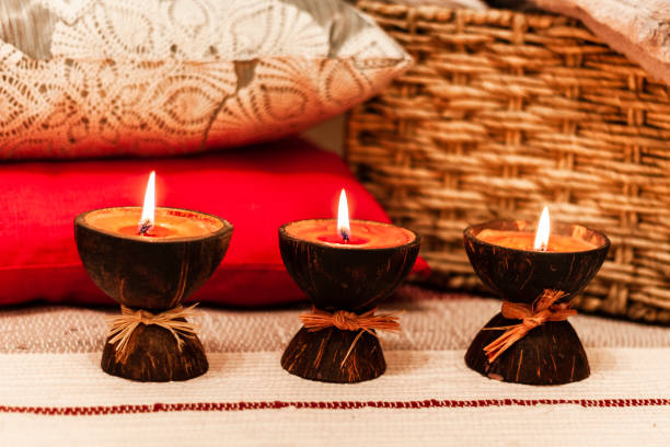 istock Burning spa aroma candles in coconut shell, pillows and plaid, cozy home interior background.. 1086048252