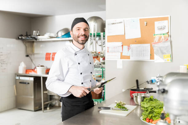 istock Smiling Cook Sharpening Blade Of Knife In Kitchen 1086048824