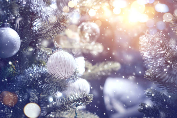 istock White and silver bauble hanging from a decorated Christmas tree with background. 1086051840