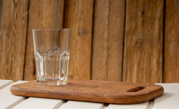 Empty glass cup on a wooden table, with space for writing text,