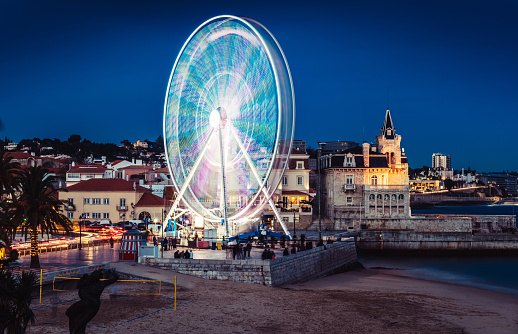 Long exposure of giant ferris wheel entertaining locals and tourists at Cascais Beach during the Christmas Season at night