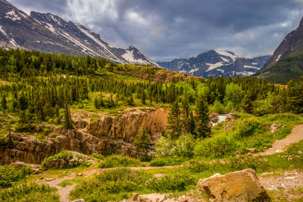 istock Green foreground snow capped mountains gray skies 1086060134