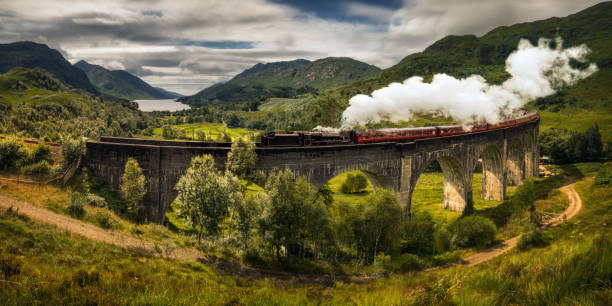 Steam train Jacobite Panorama of Jacobite steam train on old bridge, Scotland lochaber stock pictures, royalty-free photos & images
