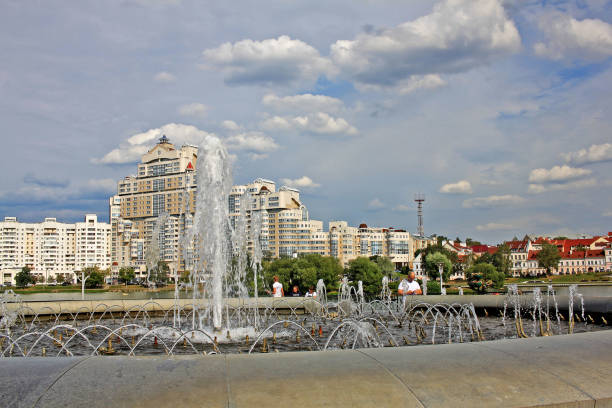 Minsk, Belarus - 13 August 2018: Fountain and High rise apartment house on Svislach river embankment near Trinity Hill