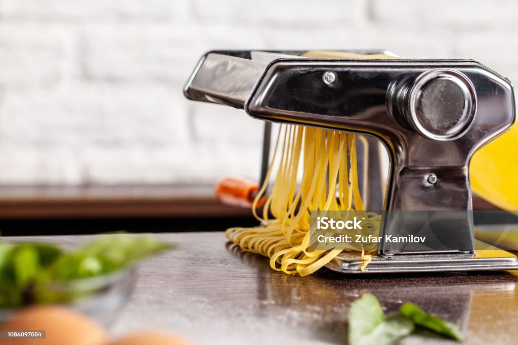 https://media.istockphoto.com/id/1086097054/photo/step-by-step-manual-process-of-making-italian-pasta-fettuccine-home-pasta-with-pasta-maker.jpg?s=1024x1024&w=is&k=20&c=sbLAQO3p4vNuylu-EYGqoJmp2lhcsZLHdx4MkFnoA70=