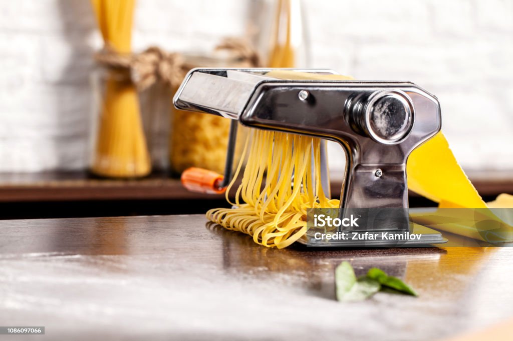 Step By Step Manual Process Of Making Italian Pasta Fettuccine Home Pasta  With Pasta Maker Flour Semola Di Grano Duro Eggs Tomatoes Basil Lie On A  Wooden Table For The Recipe Stock
