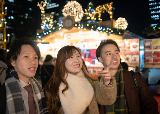 istock Young friends looking at the same direction in Christmas market 1086097230