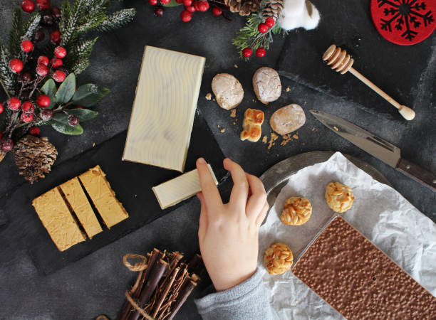 Eating Spanish Christmas sweets, turron, marzipan and polvorones Eating Spanish Christmas sweets, turron, marzipan and polvorones. Flat lay marzipan stock pictures, royalty-free photos & images