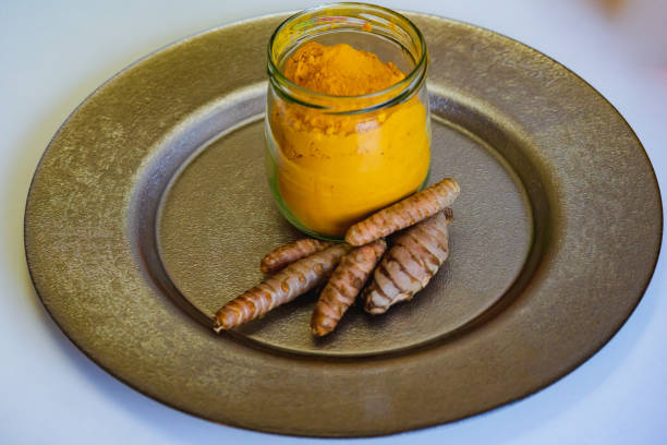 colorful indian spices turmeric and cardamom in a glass jar and mortar for spices close up. - cardamom cinnamon mortar and pestle herb imagens e fotografias de stock