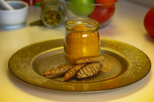 colorful indian spices turmeric and cardamom in a glass jar and mortar for spices close up. - cardamom cinnamon mortar and pestle herb imagens e fotografias de stock