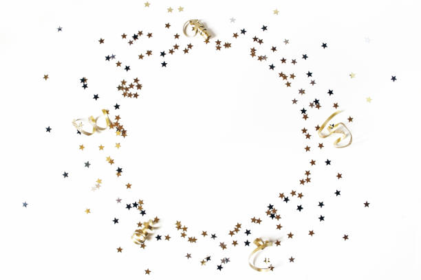 New Year festive composition. Circle made of black, silver and gold confetti stars and ribbons. Party decoration, celebration concept. Flat lay, top view. Empty space. stock photo