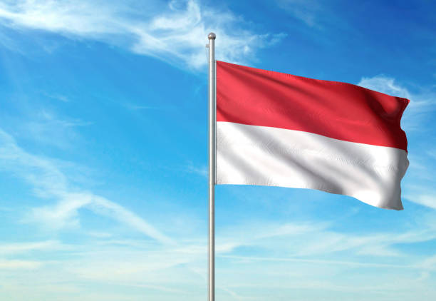 istock Indonesia and Monaco flag waving cloudy sky background 1086106398