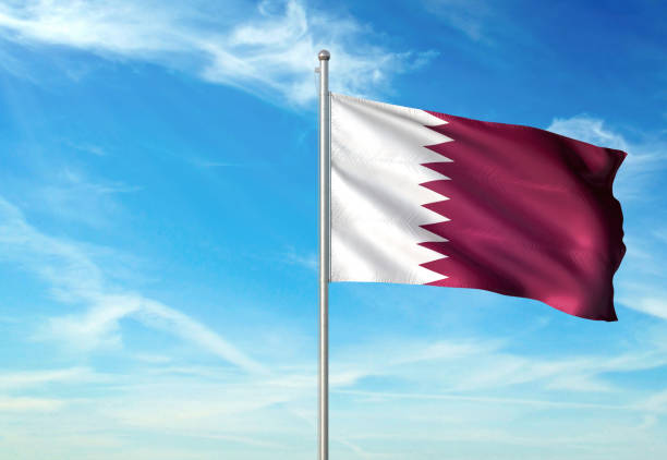 istock Qatar flag waving cloudy sky background 1086106584