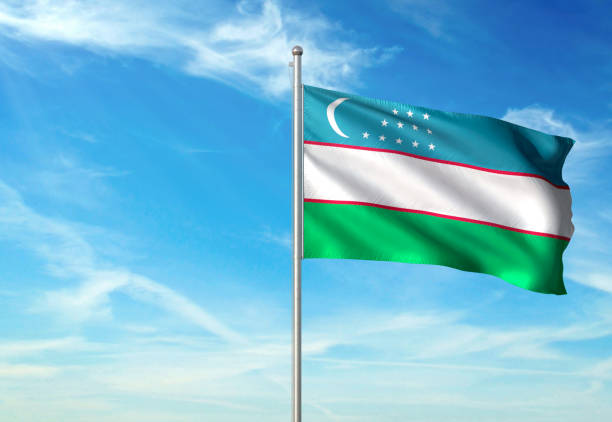 istock Uzbekistan flag waving cloudy sky background 1086109812