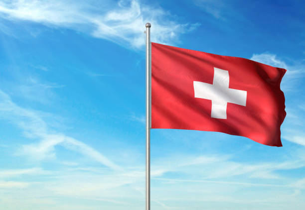 istock Switzerland flag waving cloudy sky background 1086111068