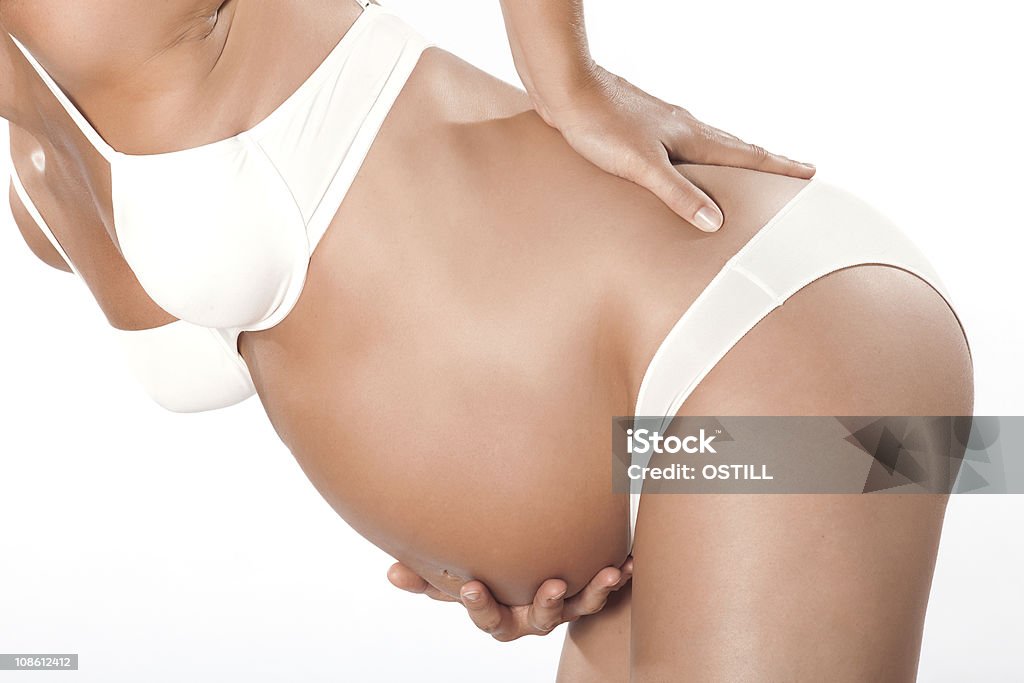 one Pregnant woman detail backache one caucasian pregnant woman detail backache  in studio isolated on white background Pain Stock Photo