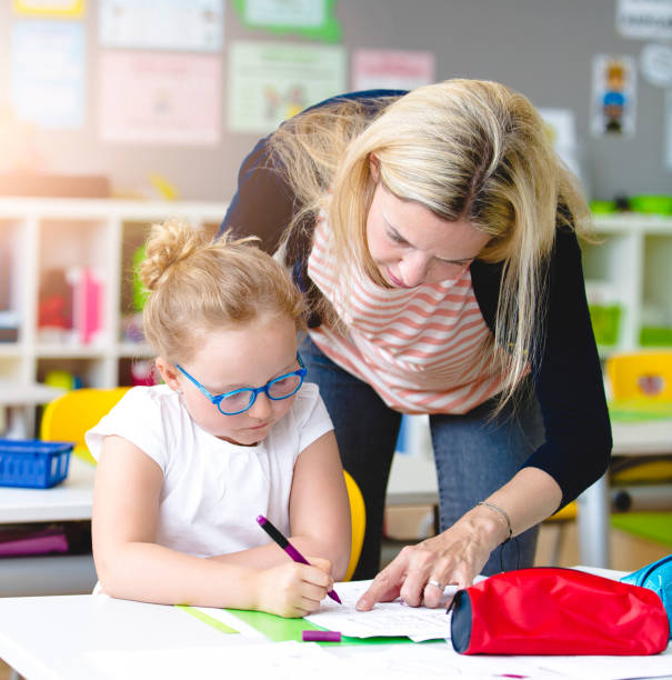istock Teacher Assisting Student In Studying At Classroom 1086125260