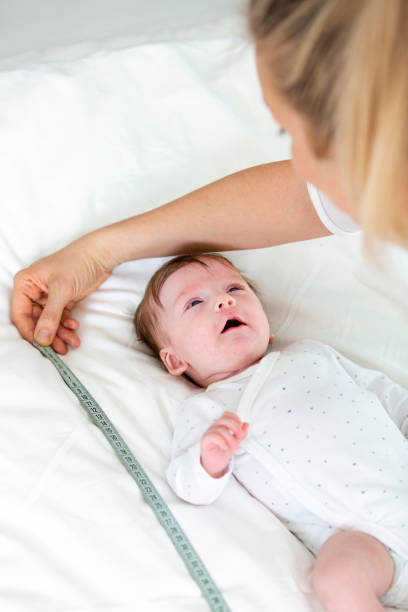 istock Mother Measuring Baby On Bed 1086128468