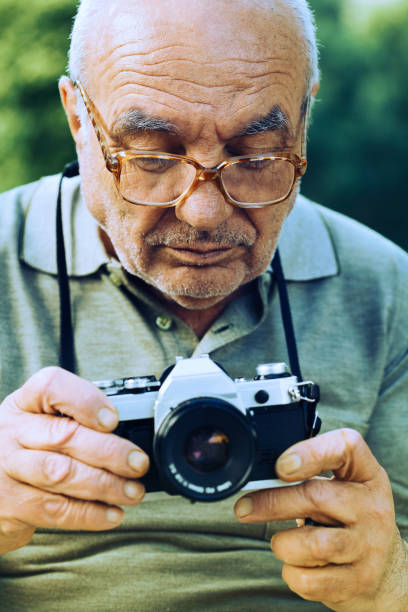 istock Senior photographer with vintage camera 1086144790