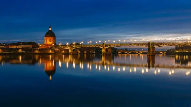 View of Garonne River at night, with reflections of Saint-Pierre Bridge and Chapel of hÃ´pital Saint-Joseph de la Grave, in Toulouse, France