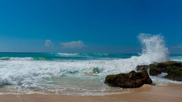 istock Ocean wave splashes against the beach rocks 1086155620