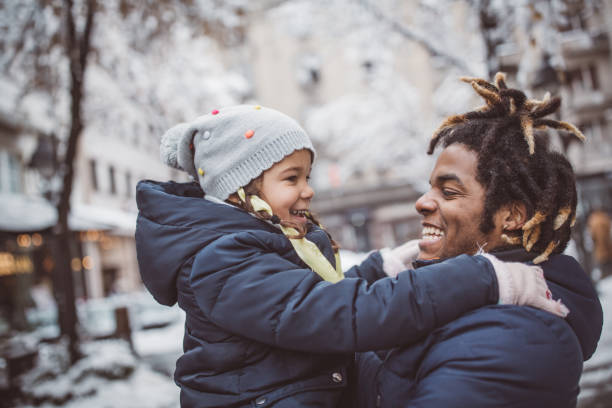 They love winter and snow Young father with daughter walking on snowy street and enjoy in winter magic. They wearing warm clothing single father stock pictures, royalty-free photos & images