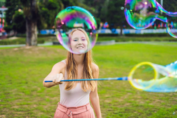 istock Happy carefree young woman blowing soap bubbles 1086173532