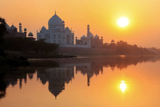 taj mahal spiegelt sich im fluss yamuna bei sonnenuntergang in agra, indien - yamuna river stock-fotos und bilder