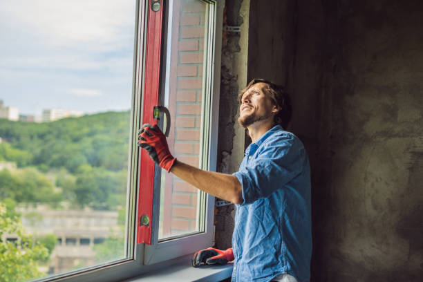 istock Man in a blue shirt does window installation 1086178742