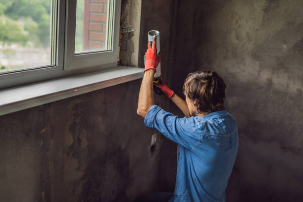 istock Man in a blue shirt does window installation 1086178752