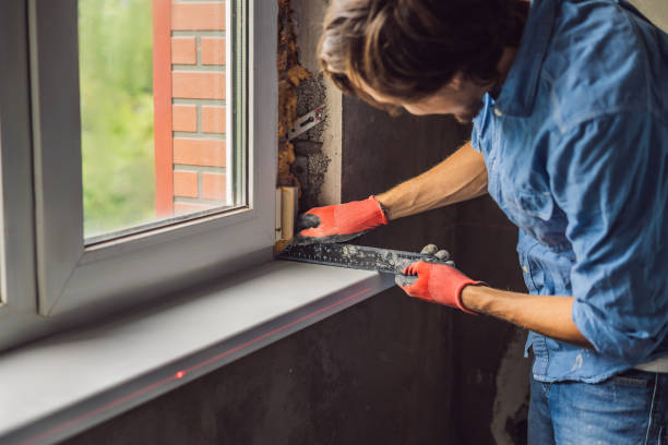 istock Man in a blue shirt does window installation 1086178788