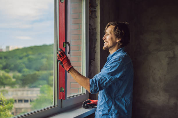 istock Man in a blue shirt does window installation 1086178798