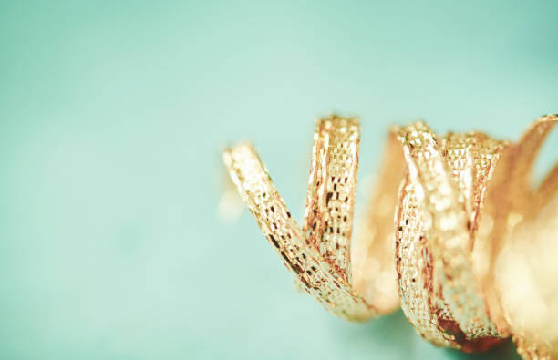 Curly gold ribbon with teal background