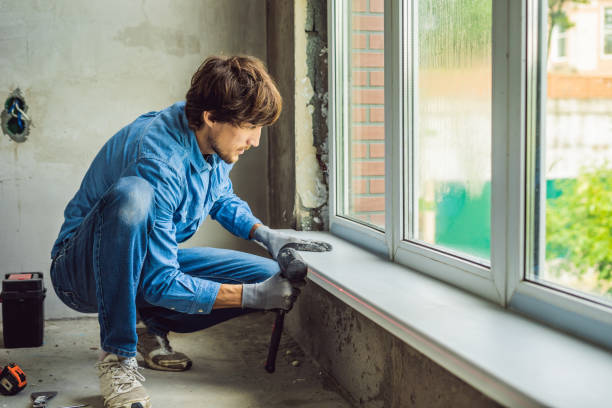 istock Man in a blue shirt does window installation 1086180982