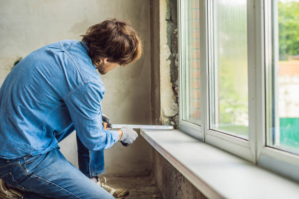 istock Man in a blue shirt does window installation 1086180996