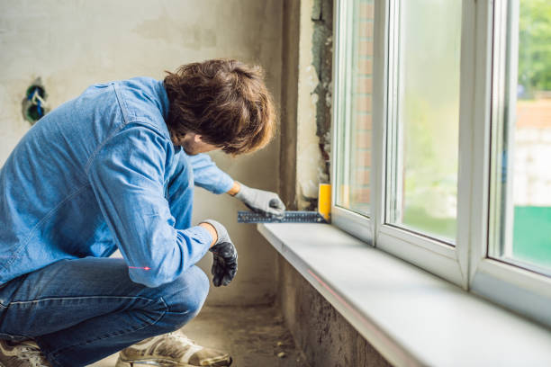 istock Man in a blue shirt does window installation 1086181000