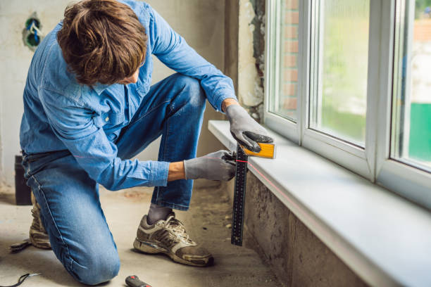 istock Man in a blue shirt does window installation 1086181012