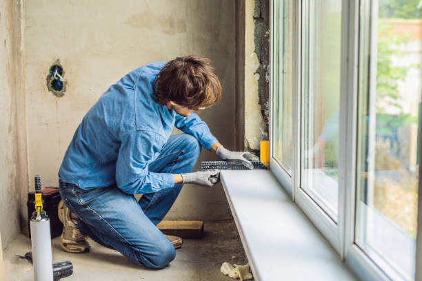 istock Man in a blue shirt does window installation 1086181084