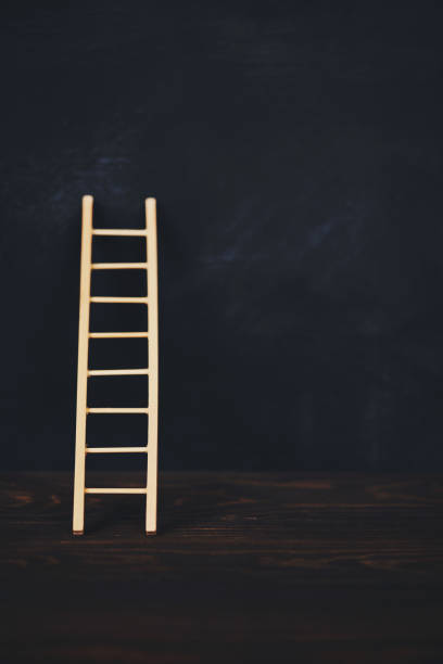 istock Ladder leaning against blank chalkboard 1086182818