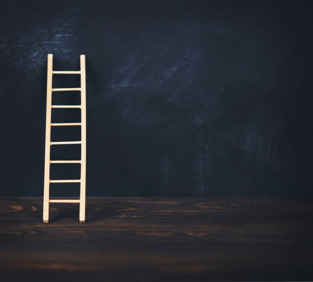 istock Ladder leaning against blank chalkboard 1086182828