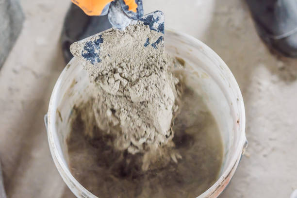 istock Man making cement with a construction mixer in a bucket 1086183310