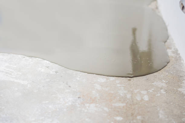 istock plasterer during floor covering works with self-levelling cement mortar 1086183312