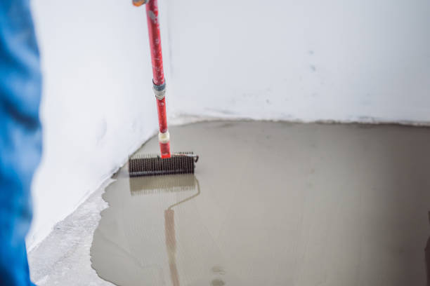 istock plasterer during floor covering works with self-levelling cement mortar 1086183318