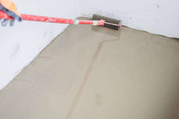 istock plasterer during floor covering works with self-levelling cement mortar 1086183330