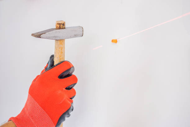 istock Man twists a screw into the wall 1086184592