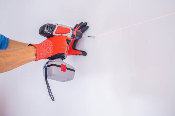 istock Man twists a screw into the wall 1086184596