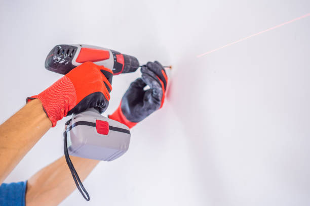 istock Man twists a screw into the wall 1086184600