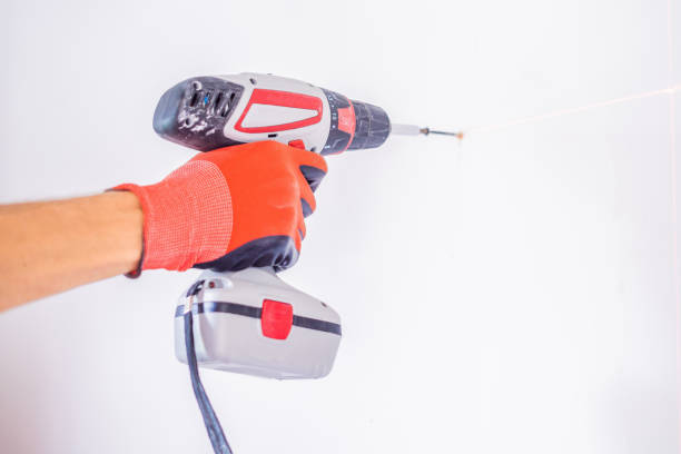 istock Man twists a screw into the wall 1086184604